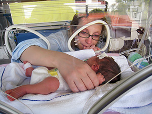 Mujer que mira a un bebé en una incubadora
