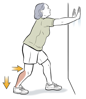 Woman leaning hands on wall doing soleus stretch.